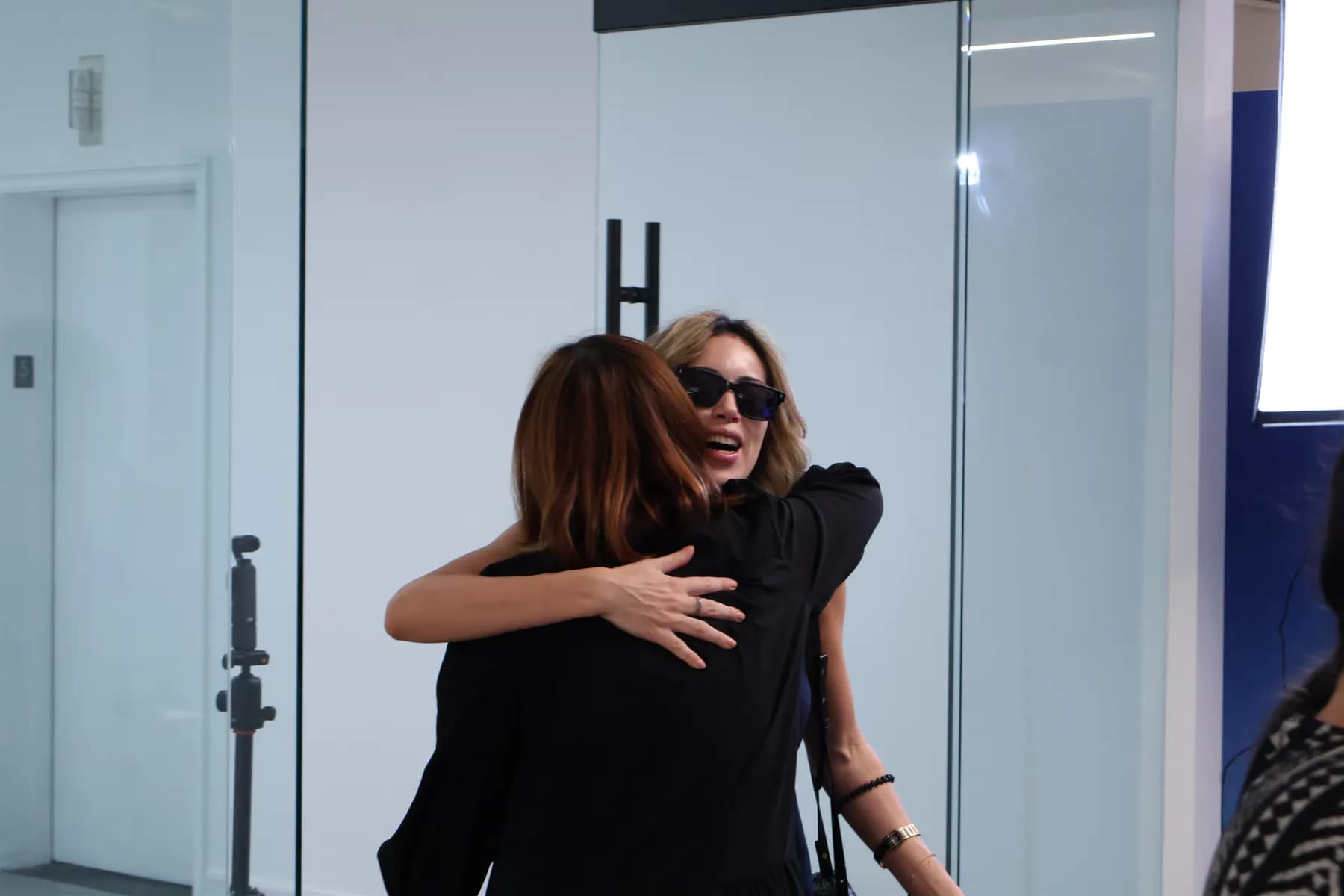 Two guests greet each other with a warm hug at the MiPalette event.