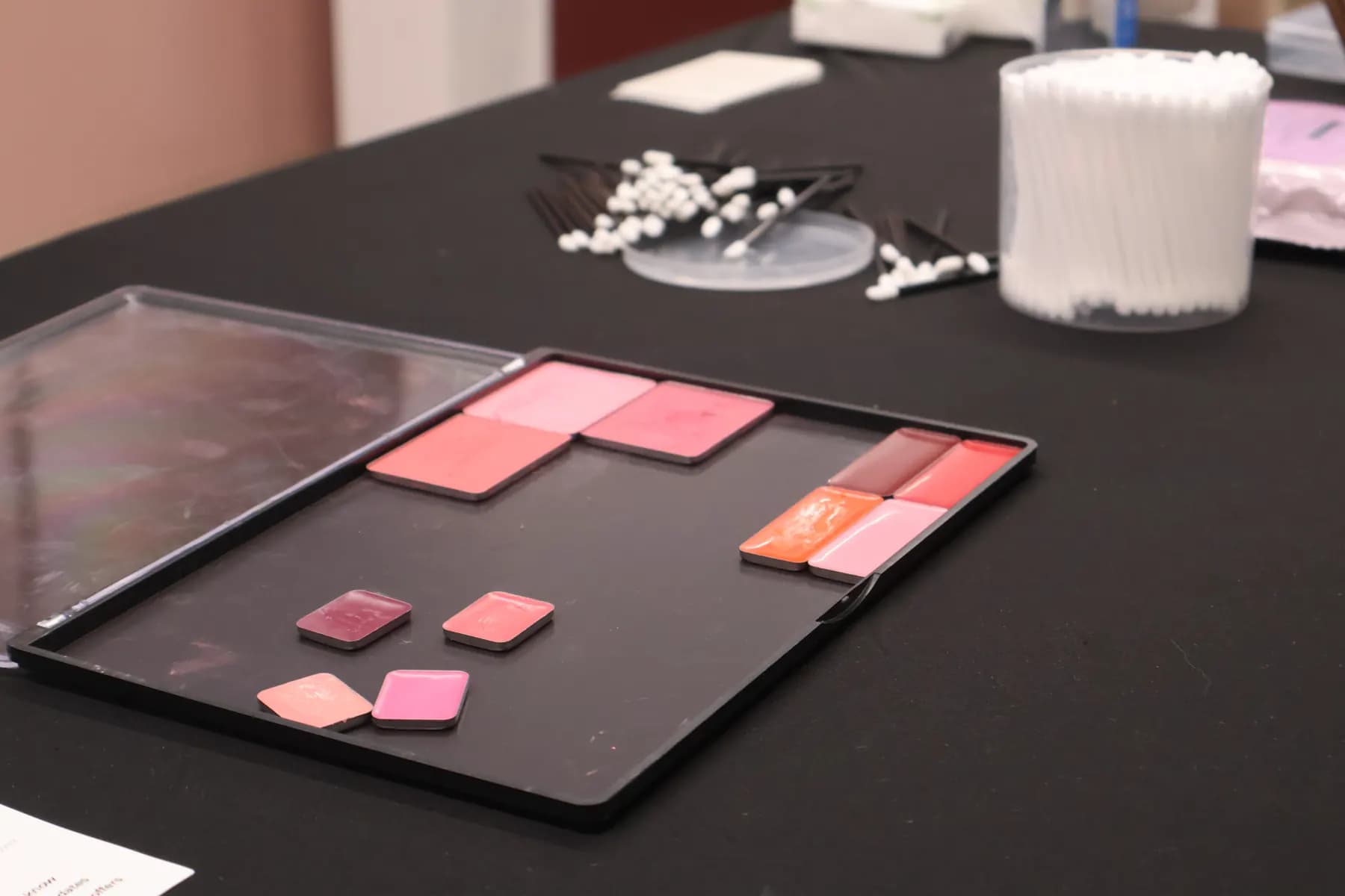 Pink and neutral MiPalette refill pans arranged on a black display tray.