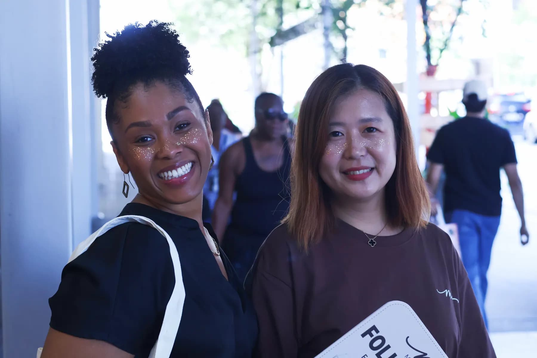 Two women smile together during the MiPalette New York pop-up.