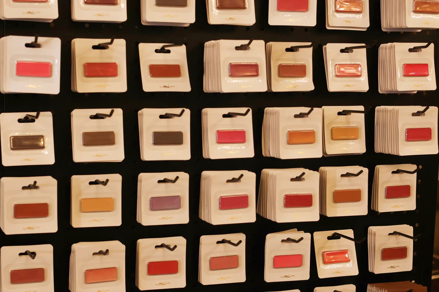 Close-up of MiPalette refill shades arranged by color on a black display wall.